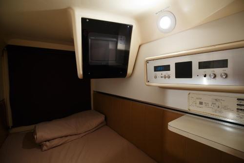 a small room with a tv on the wall at The Nell Ueno Okachimachi in Tokyo