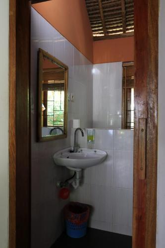 y baño con lavabo y espejo. en Albany Home Stay, en Kuta Lombok