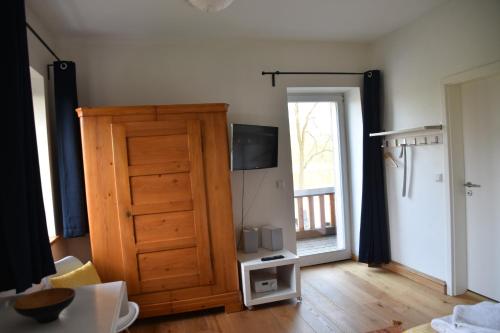 a living room with a wooden door and a television at Seehaus Hartwigsdorf in Klein Vielen