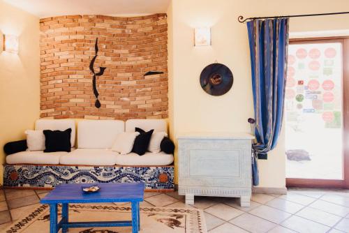 a living room filled with furniture and a wall clock at Hotel Luci Del Faro in Calasetta
