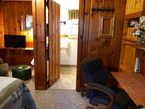 a bedroom with a bed and a desk and a chair at Cedar Ridge Cabins in Honor
