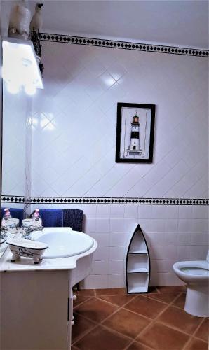 a bathroom with a sink and a toilet at Casa Rustica do Lagar in Lamas