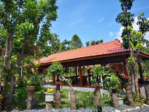 a house with a bunch of potted plants in front of it at Taluangjit Resort&Garden in Khiriwong