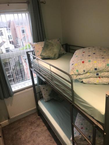 a bedroom with two bunk beds and a window at Cornwall Apartments in Blackpool