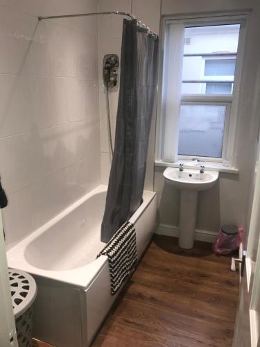 ein Badezimmer mit einer Badewanne und einem Waschbecken in der Unterkunft Cornwall Apartments in Blackpool
