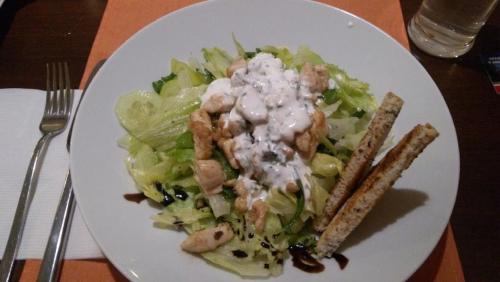 a white plate of food with a salad on a table at Grand Apartments Hrebienok in Smokovce
