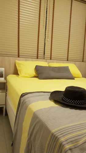 um quarto com 2 camas com lençóis amarelos e um chapéu em Solar Água 172 em Pipa