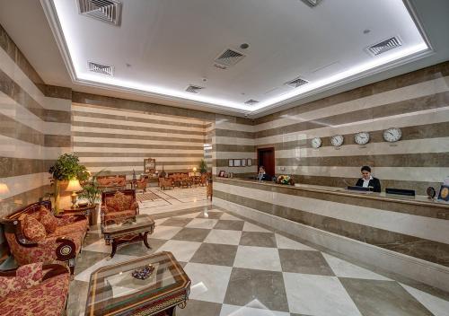 a lobby with a woman sitting at a counter at Marina Hotel Apartments in Dubai