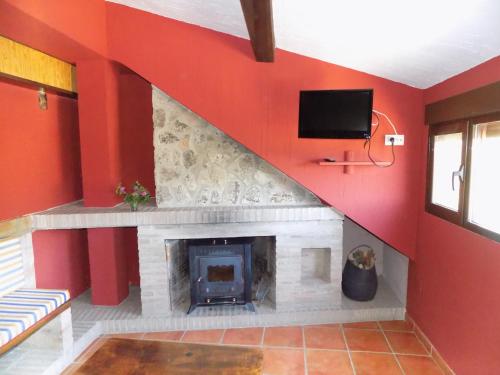 sala de estar con chimenea y TV en Fuente Del Gamellon, en Buenache de la Sierra