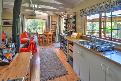 a kitchen with a sink and a living room at Maple Grove in Hogsback