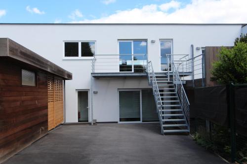 a stairway leading to a white house at Nuvola Loft in Zottegem