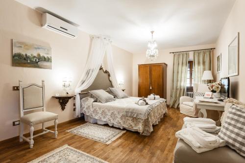 a white bedroom with a bed and a couch at Giardino della Pieve Relais- Adult Only in Cascina