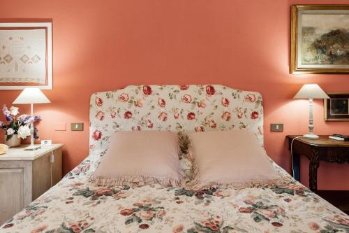 a bedroom with a bed with a floral bedspread at Giardino della Pieve Relais- Adult Only in Cascina