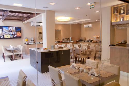 une salle à manger avec des tables et des chaises dans un restaurant dans l'établissement Grande Hotel Petrópolis, à Petrópolis