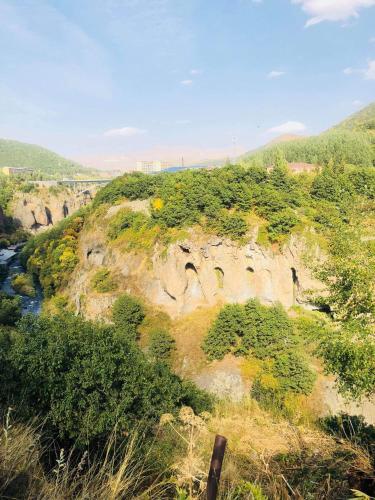 a rocky hillside with a river and trees at Rest house Jermuk in Jermuk