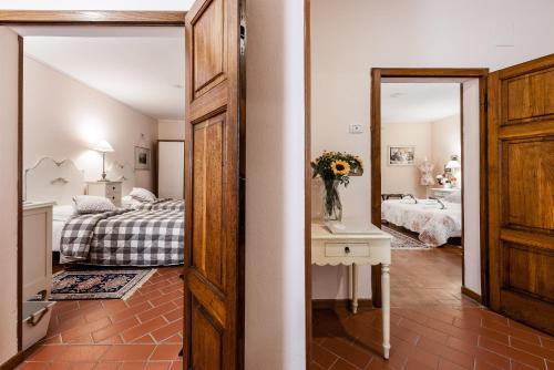 a bedroom with a bed and a vase of flowers on a table at Giardino della Pieve Relais- Adult Only in Cascina