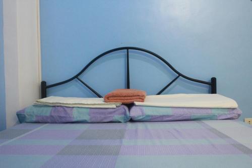 a bed with two pillows on it in a room at Mayon Lodging House in Legazpi