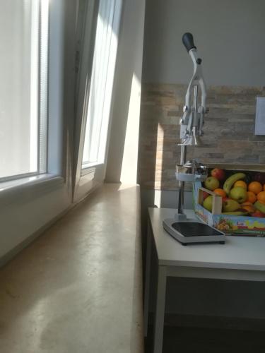 a kitchen counter with a bowl of fruit next to a window at B&B Purple Italy in Fiumicino