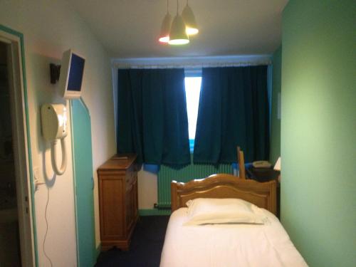a small bedroom with a bed and a window at Hotel Couleurs Sud Centre-ville Gare Charleville-Mézières in Charleville-Mézières