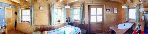 a room with a wooden wall with a door and windows at Stranighütte in Obervellach