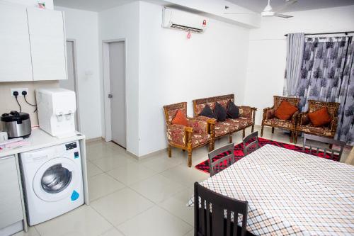 a kitchen with a washing machine and a table at I-city Sweet in Shah Alam