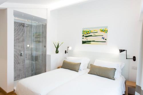 a white bedroom with two beds and a shower at Villa Fiorella Art Hotel in Massa Lubrense