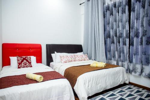 Un dormitorio con dos camas con almohadas encima. en I-city Sweet, en Shah Alam