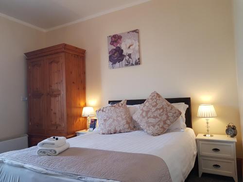 a bedroom with a bed with two night stands and two lamps at Waterfront Hotel in Deal