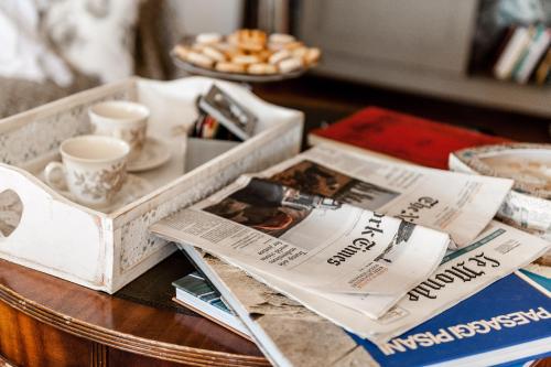 a table with magazines and newspapers on a table at Giardino della Pieve Relais- Adult Only in Cascina