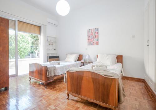 a bedroom with two beds and a large window at Sunny Family Home By The Beach in Limassol