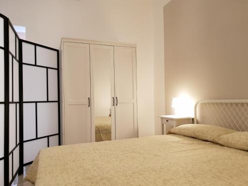 - une chambre blanche avec un lit et un placard dans l'établissement Rifinito bilocale in centro, Casa Verdi, 2° Piano, à Bagheria