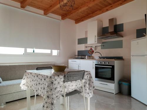 une petite cuisine avec une table et un canapé dans l'établissement Rifinito bilocale in centro, Casa Verdi, 2° Piano, à Bagheria