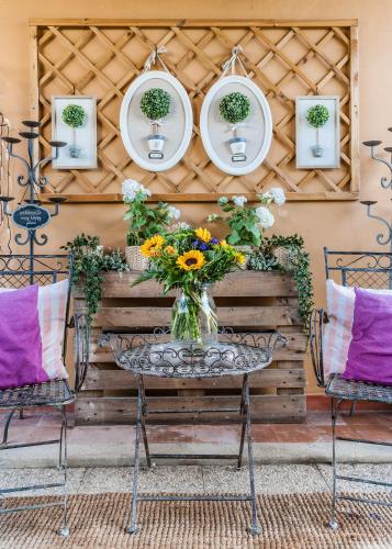 a table with a vase of flowers on a patio at Giardino della Pieve Relais- Adult Only in Cascina