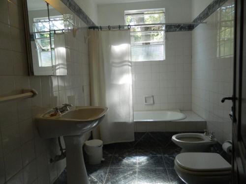 a bathroom with a sink and a tub and a toilet at Hostal El Cerrito San Lorenzo in San Lorenzo