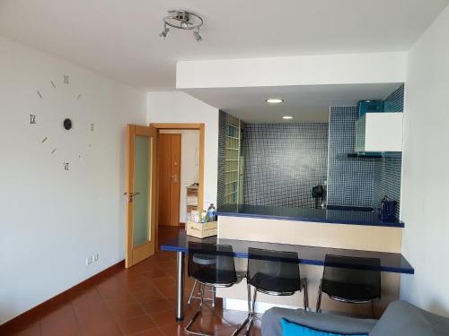 eine Küche mit einer blauen Theke und einigen Stühlen in der Unterkunft Xperience Algarve - Ocean Terrace in Armação de Pêra