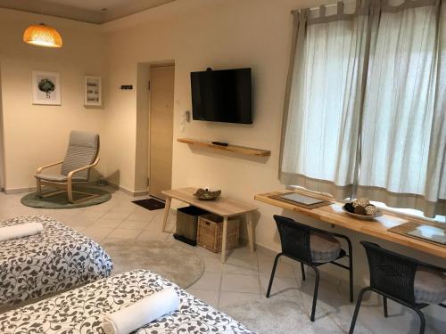 Habitación con escritorio, TV y cama. en Flight Apartments Airport by Airstay en Spáta
