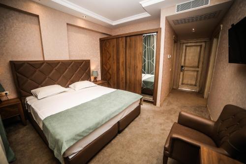 um quarto com uma cama grande e uma cadeira em Boutique Hotel Mimino em Tbilisi
