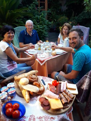 a group of people sitting at a table with food at Fónagy és Walter Vendég- és Borház in Vác