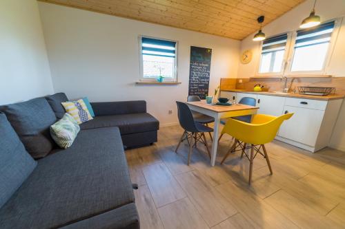 a living room with a couch and a table and a kitchen at Strumyk Marzeń in Mikołajki