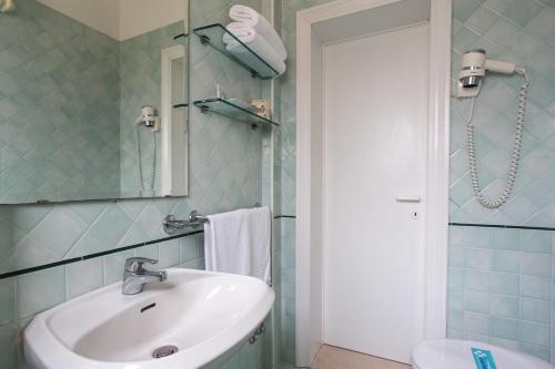 bagno con lavandino, servizi igienici e specchio di Park Hotel Serena a Rimini