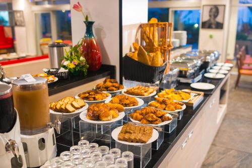 a buffet line with plates of food and drinks at ONOMO Hotel Conakry in Conakry