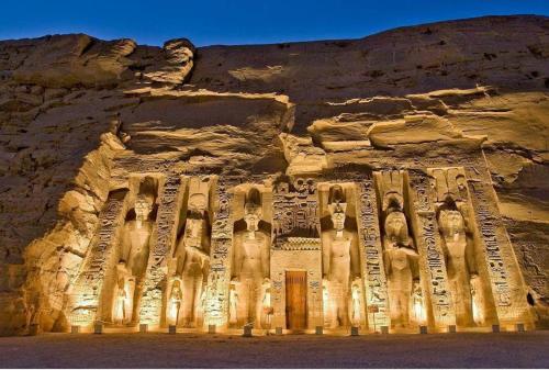 an ancient building in a cliff with reliefs on it at El Mesala Hotel in Luxor