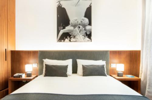 a bedroom with a large bed with two tables and two lamps at Garibaldi 66 Brera in Milan