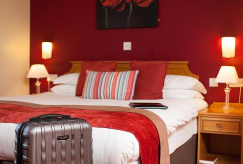 a hotel room with two beds and a suitcase at Adelphi Portrush in Portrush