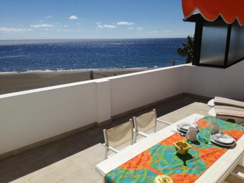 a table and chairs with a view of the ocean at ÁTICO EN PRIMERA LINEA DE PLAYA in Gran Tarajal