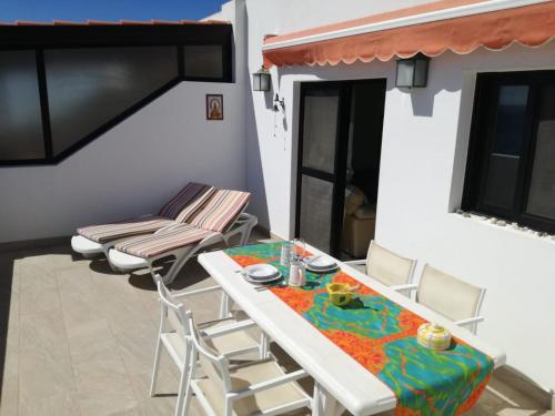 a dining room with a table and chairs on a balcony at ÁTICO EN PRIMERA LINEA DE PLAYA in Gran Tarajal