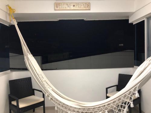 a hammock in a room with two chairs at Sashii Hostel & Boutique. in Ríohacha