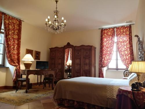 um quarto com uma cama, uma secretária e janelas em B&B Castello di Camerletto em Caselette