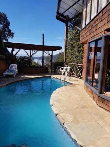 a swimming pool in front of a house at La Rueda del Chucao in Valdivia