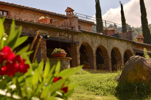 an old brick building with potted plants on it at Podere Mazzarelle in Castel del Piano